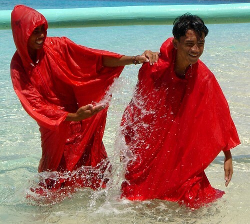 happy friends in wet ponchos